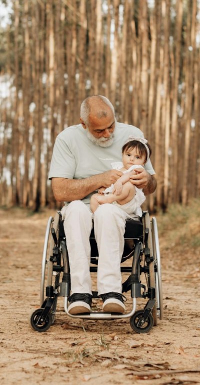 man in wheelchair holding child